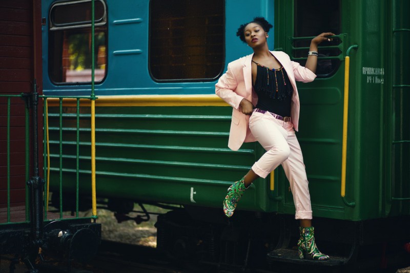 A woman posing in front of the train in ankle boots