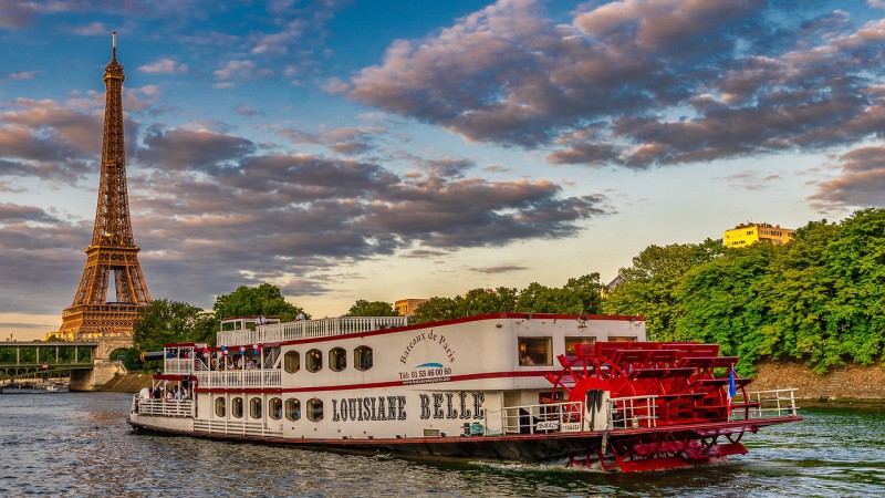 Boat cruise on Siene river passes by Eiffel Tower