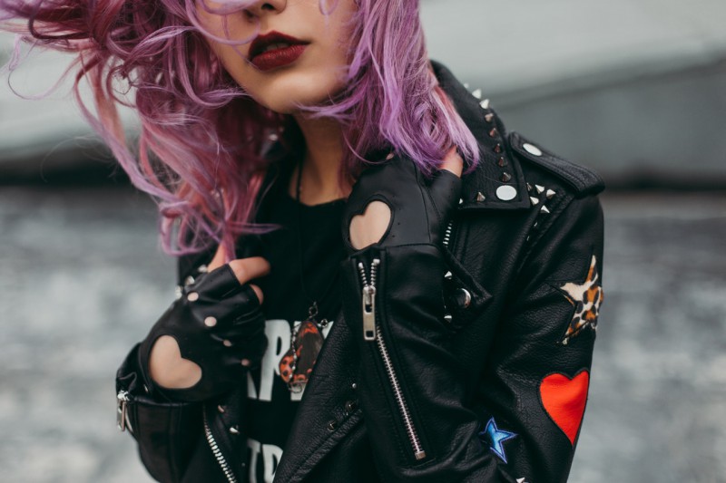 A woman  with violet hair wearing dark lipstick