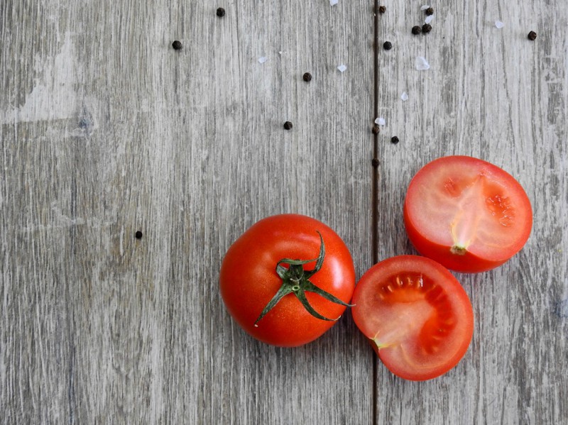 Two tomatoes, one of them sliced in half