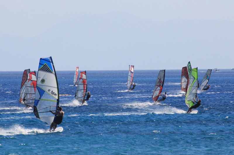 A group of windsurfers on the sea.