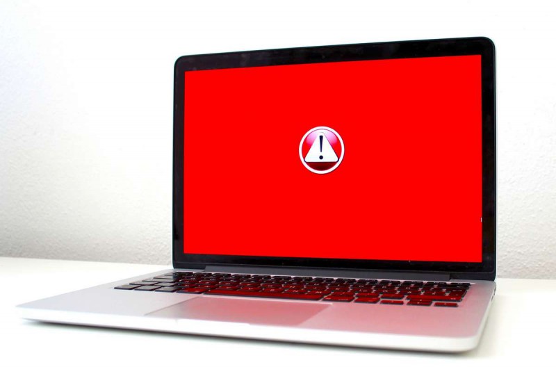 A laptop screen showing a warning sign