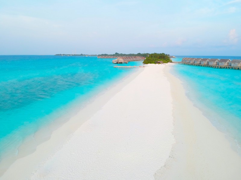 White sandy beach surrounded by light blue water at the Maldives