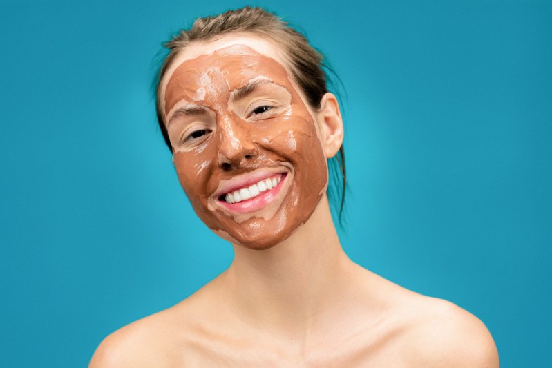 Clay mask on a smiling girl