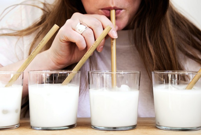 A woman drinking milk using a straw
