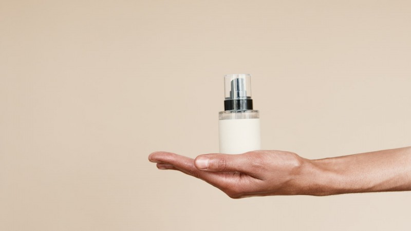 A woman holding moisturizer in her hand